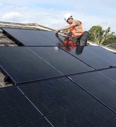 Man fitting solar panels on a roof