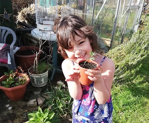 Rons Plot child shows off seedling