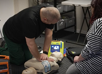 Michael with a CPR dummy and defibrillator